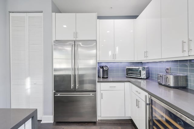 kitchen with white cabinets, beverage cooler, and built in fridge