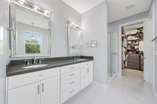 bathroom featuring tile patterned floors, vanity, and a shower with shower door