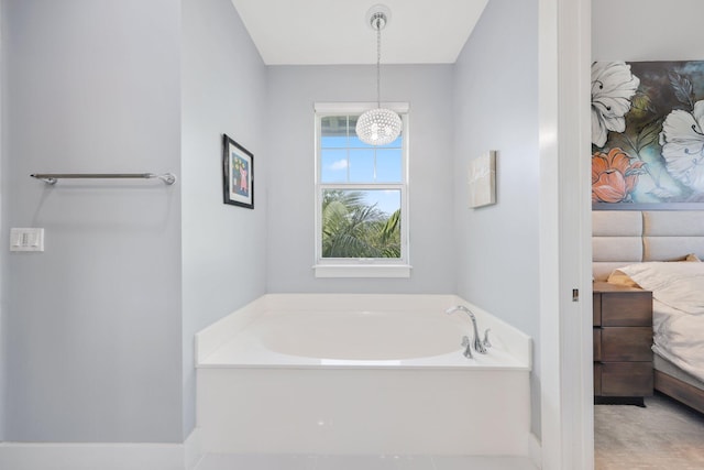 bathroom with a tub and a chandelier