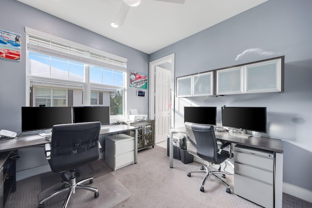 carpeted home office featuring ceiling fan