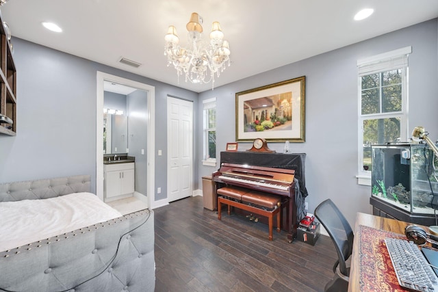 bedroom with a chandelier, dark hardwood / wood-style flooring, ensuite bath, and multiple windows