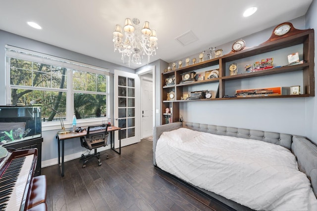 bedroom featuring dark hardwood / wood-style flooring and a notable chandelier