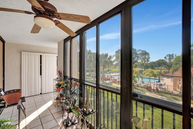 sunroom / solarium with a water view and ceiling fan