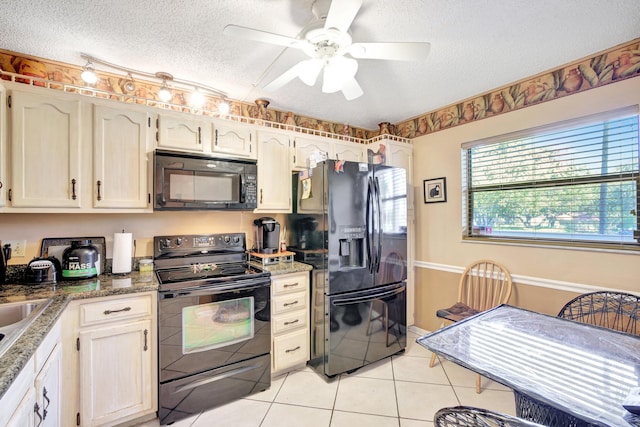 kitchen featuring a textured ceiling, ceiling fan, black appliances, dark stone countertops, and light tile patterned flooring