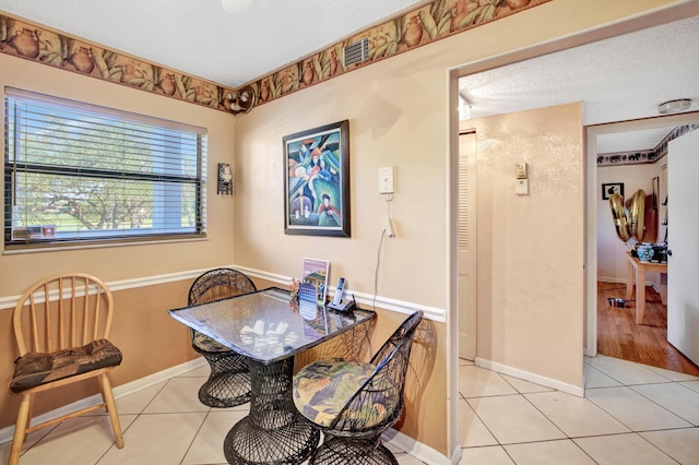 dining room featuring a textured ceiling and light tile patterned flooring