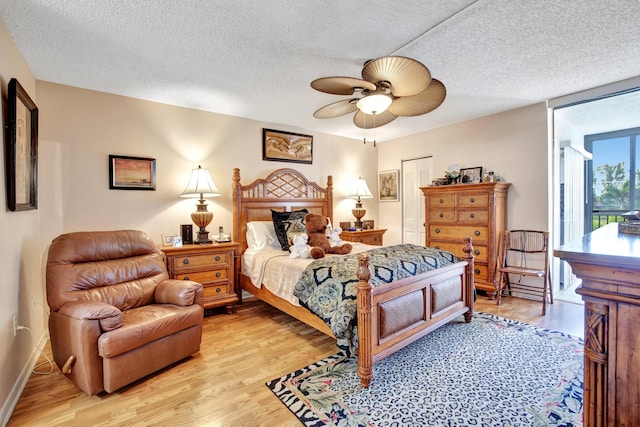 bedroom featuring ceiling fan, light hardwood / wood-style floors, and a textured ceiling