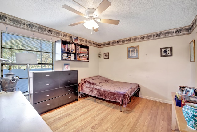 bedroom with a textured ceiling, light wood-type flooring, and ceiling fan