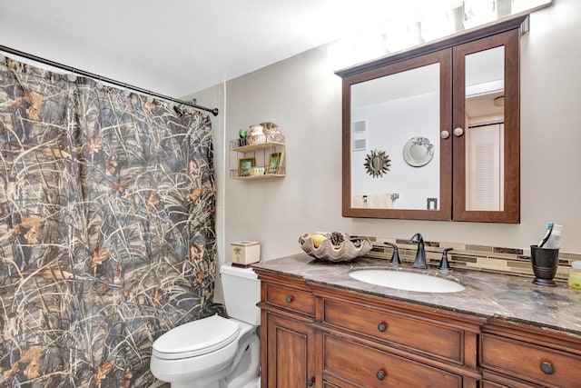 bathroom featuring a shower with shower curtain, vanity, and toilet