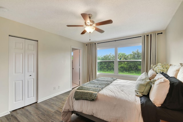 bedroom with a closet, a textured ceiling, dark hardwood / wood-style floors, and ceiling fan