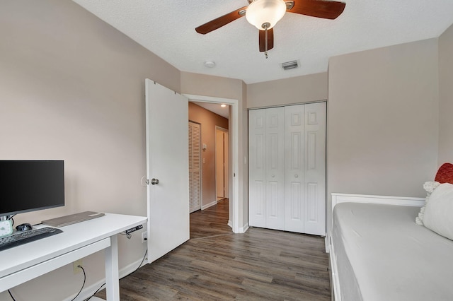 interior space with ceiling fan, dark hardwood / wood-style flooring, a textured ceiling, and a closet