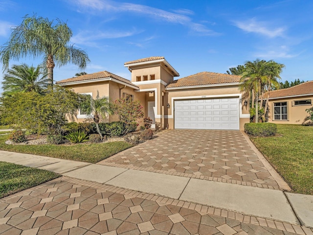 mediterranean / spanish-style house featuring a front lawn and a garage