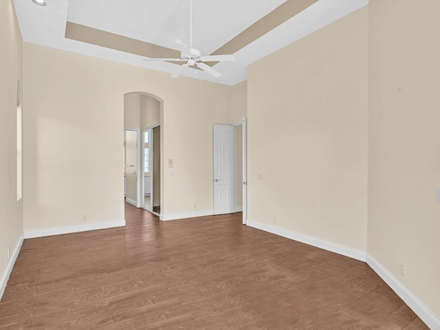 spare room featuring hardwood / wood-style floors, ceiling fan, and a tray ceiling