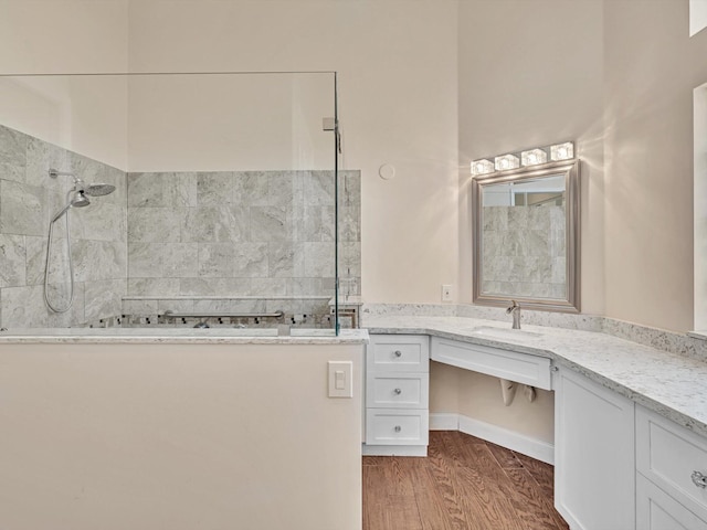 bathroom with vanity, wood-type flooring, and a tile shower
