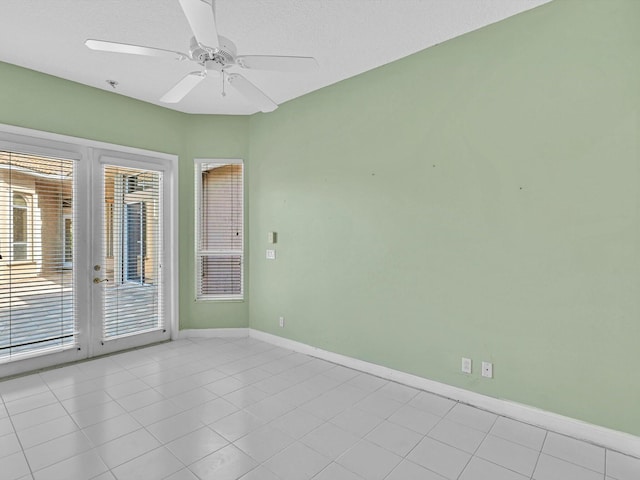 spare room featuring a wealth of natural light, french doors, ceiling fan, and light tile patterned floors