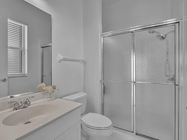 bathroom featuring tile patterned floors, vanity, toilet, and a shower with door