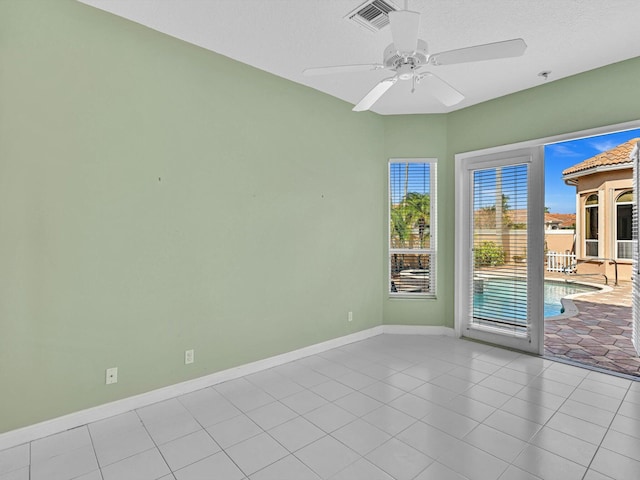 unfurnished room with light tile patterned flooring, ceiling fan, and a textured ceiling