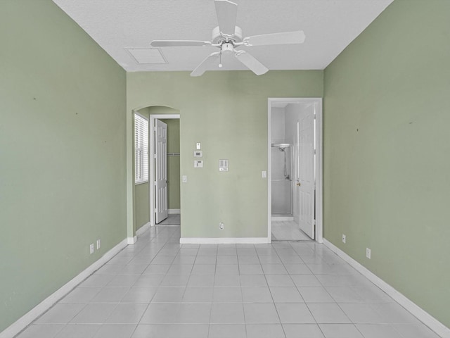 spare room featuring light tile patterned floors, a textured ceiling, and ceiling fan
