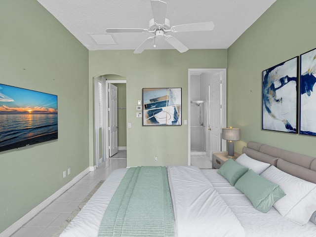 bedroom with connected bathroom, a textured ceiling, ceiling fan, and light tile patterned floors