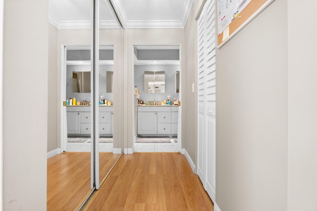 hall with crown molding, hardwood / wood-style floors, and sink