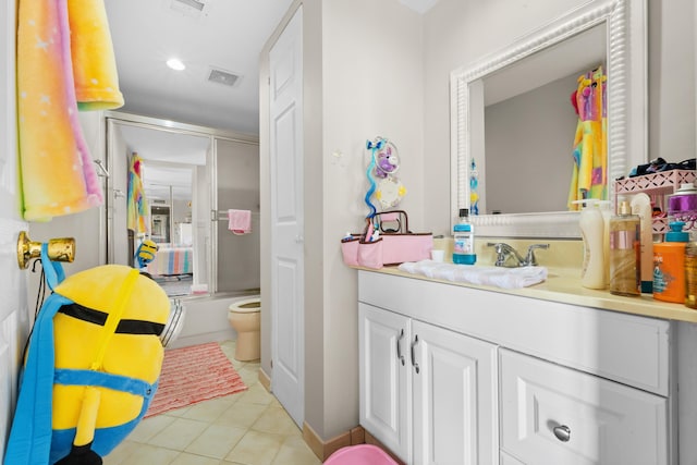 full bathroom featuring tile patterned flooring, vanity, toilet, and bath / shower combo with glass door