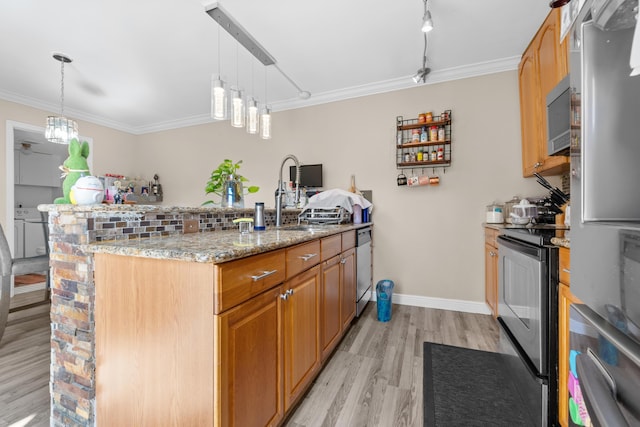 kitchen featuring light stone countertops, hanging light fixtures, appliances with stainless steel finishes, and light hardwood / wood-style flooring