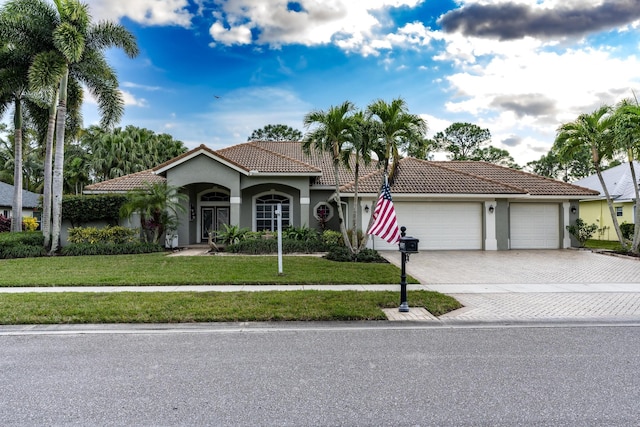 mediterranean / spanish-style home featuring a front yard and a garage