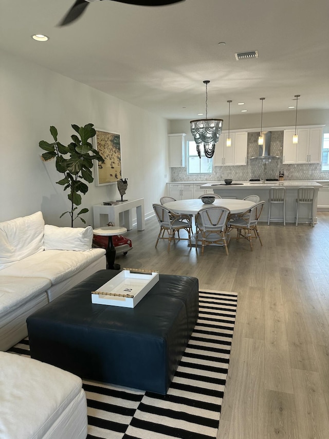 living room with a chandelier and light hardwood / wood-style floors