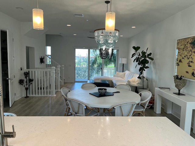 dining area featuring dark hardwood / wood-style flooring and an inviting chandelier