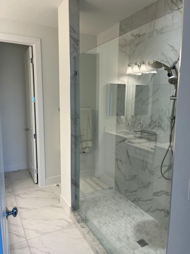 bathroom featuring tiled shower and a textured ceiling