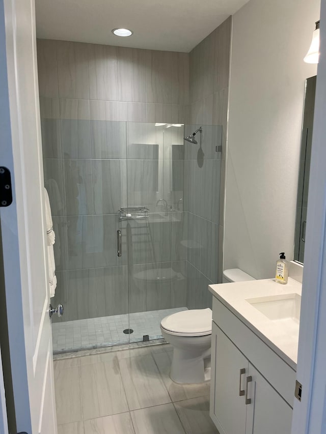 bathroom featuring vanity, an enclosed shower, and toilet