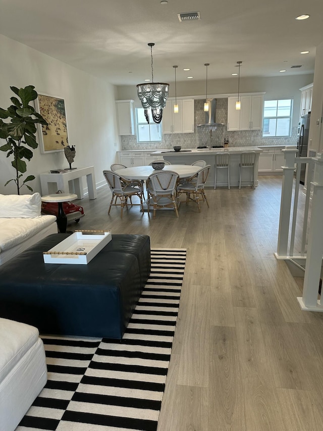 living room featuring light hardwood / wood-style floors and a notable chandelier