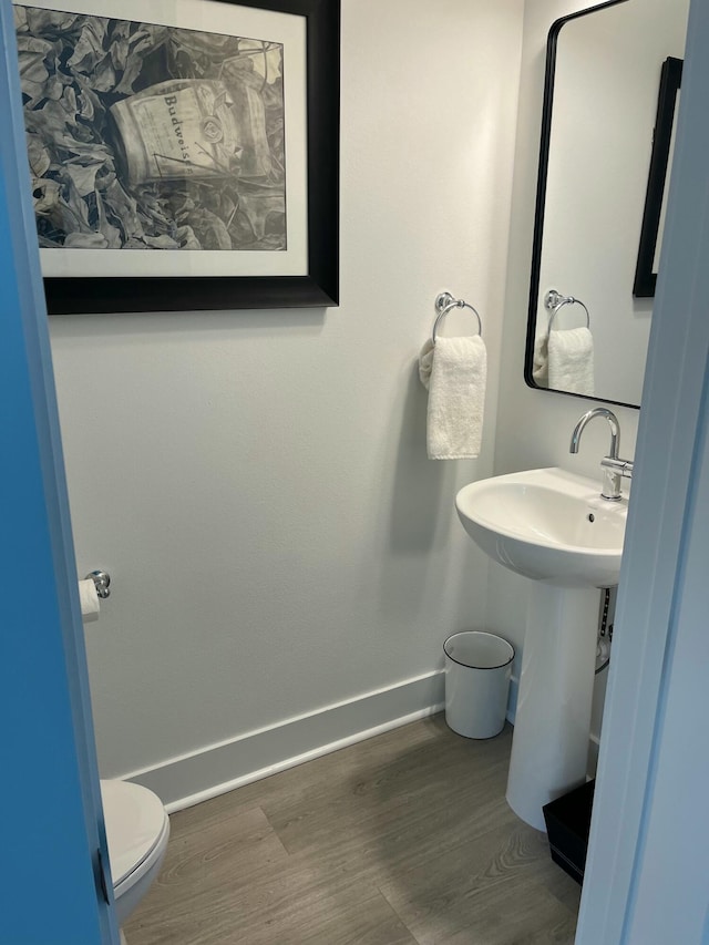 bathroom with wood-type flooring, sink, and toilet