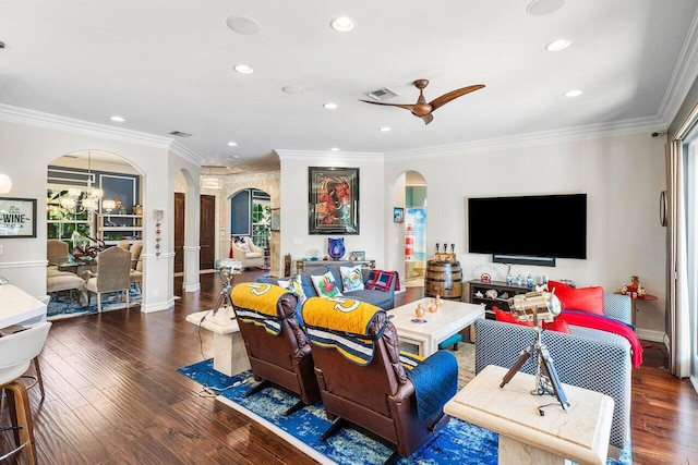 living room with dark hardwood / wood-style floors, ornamental molding, and ceiling fan with notable chandelier