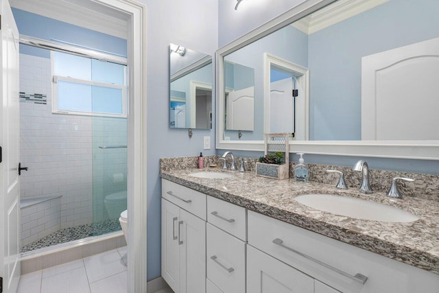 bathroom featuring tile patterned floors, vanity, a shower with shower door, and toilet