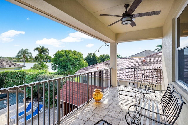 balcony featuring ceiling fan and a water view