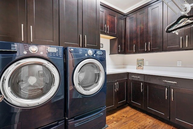 washroom with ornamental molding, washer and clothes dryer, cabinets, and light hardwood / wood-style flooring