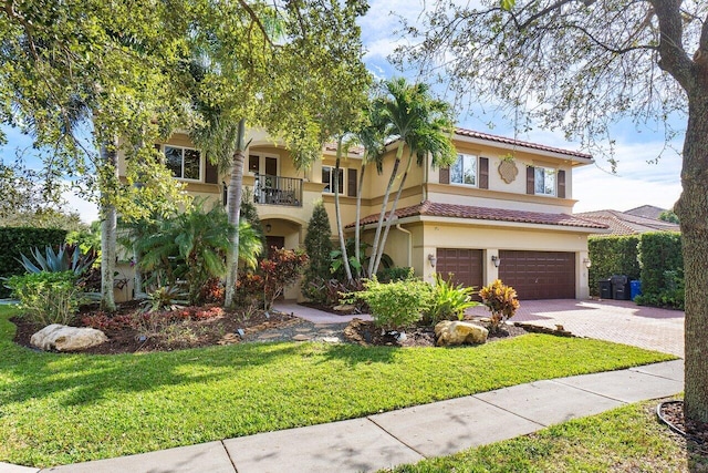 mediterranean / spanish-style house with a balcony, a garage, and a front lawn