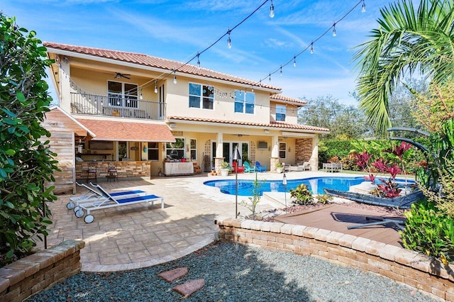 rear view of house with a patio area, ceiling fan, and a balcony