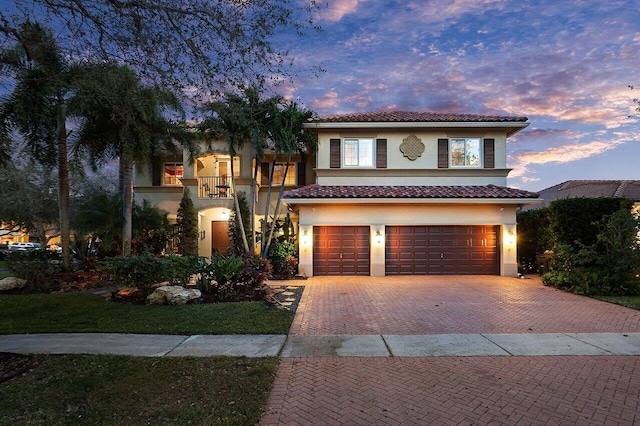 mediterranean / spanish-style home featuring a balcony and a garage