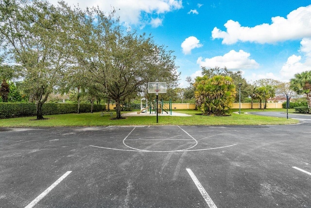 view of sport court with a lawn and a playground