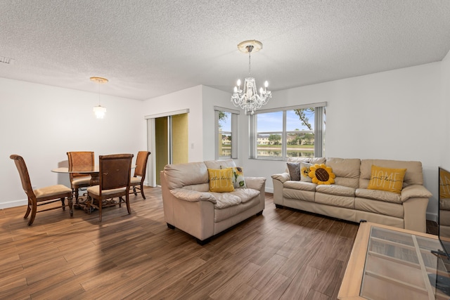 living room with a notable chandelier, a textured ceiling, and dark hardwood / wood-style floors