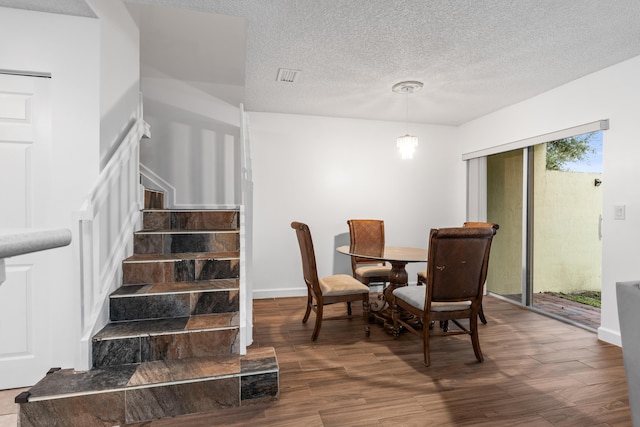 dining area featuring a textured ceiling and dark wood-type flooring