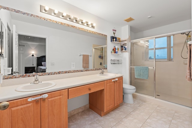 bathroom featuring toilet, walk in shower, vanity, and tile patterned flooring