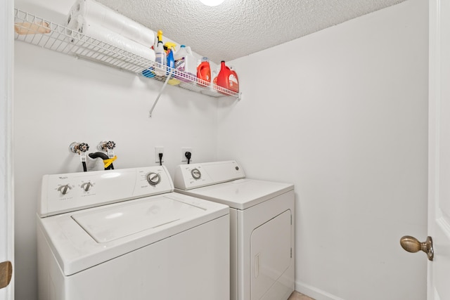 laundry room featuring washing machine and clothes dryer and a textured ceiling