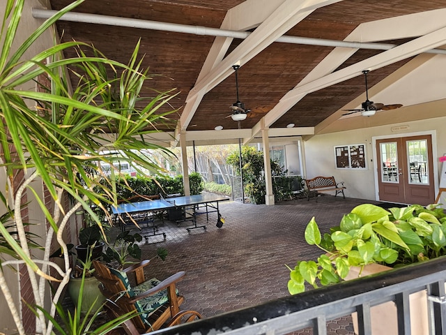 deck featuring ceiling fan, a patio area, and french doors