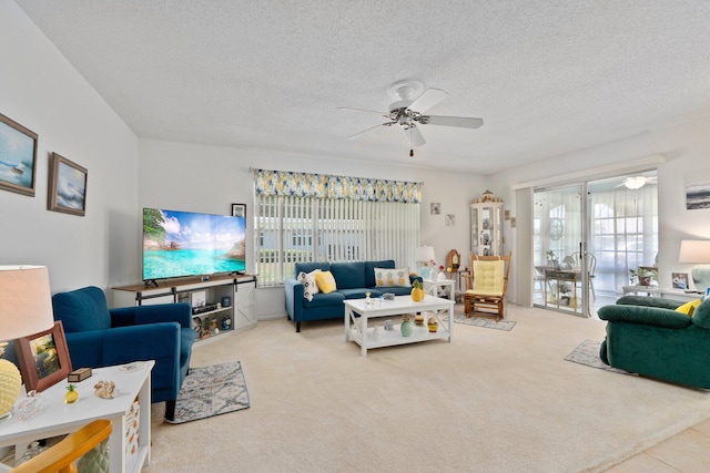 living room featuring a textured ceiling, carpet floors, and ceiling fan