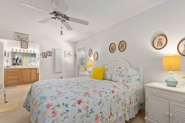 tiled bedroom featuring ceiling fan, ensuite bathroom, and a textured ceiling