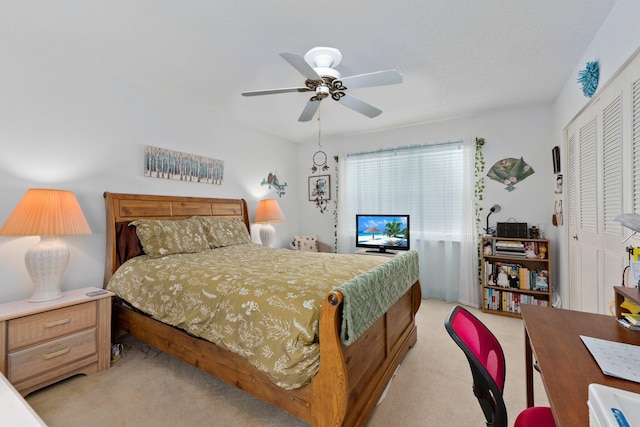 carpeted bedroom with ceiling fan and a closet