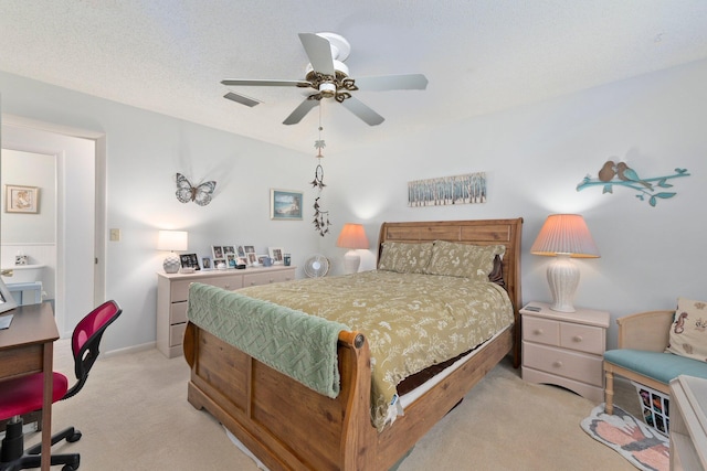 carpeted bedroom with ceiling fan and a textured ceiling