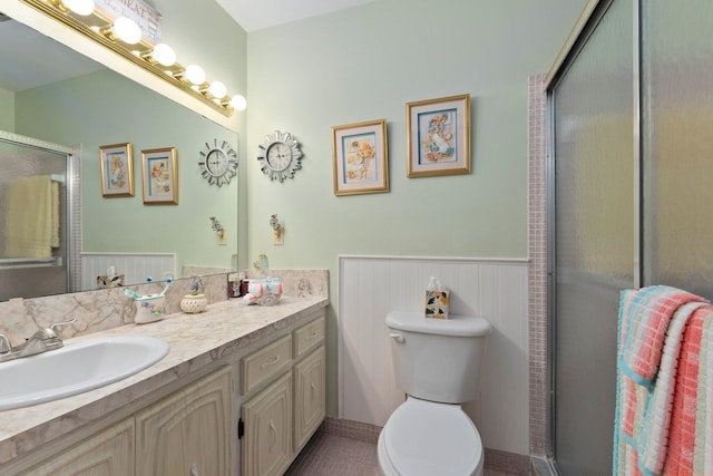 bathroom with vanity, toilet, and a shower with shower door